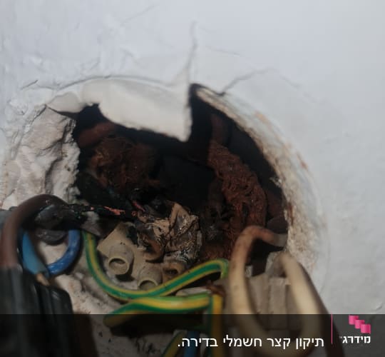 חוטי חשמל צבעוניים יוצאים מקיר עם חיבורים חשמליים